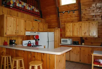 a kitchen with wooden cabinets and a white refrigerator at 46R Manzanita Lodge in Wawona