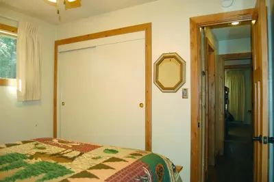a bedroom with a bed and a mirror on the wall at 78 Ox Yoke in Wawona