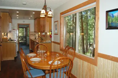a dining room with a table and chairs and a kitchen at 78 Ox Yoke in Wawona
