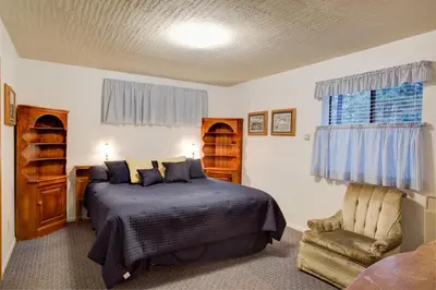 a bedroom with a bed and a chair at 22B Bradleys Cabin in Wawona