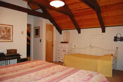 a bedroom with two beds and a wooden ceiling at 50 Spindlers Chalet in Wawona