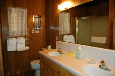 a bathroom with a sink and a toilet and a mirror at 50 Spindlers Chalet in Wawona
