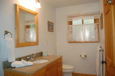 a bathroom with a sink and a toilet and a mirror at 9N Fox Hollow in Wawona