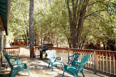 a deck with chairs and a table and a grill at 9N Fox Hollow in Wawona