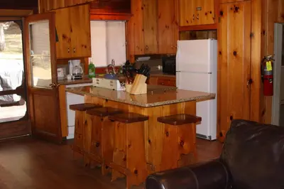 a kitchen with wooden cabinets and a white refrigerator at 76 Howards Retreat in North Wawona