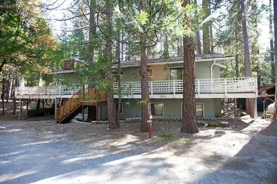 a large house with a deck in the trees at 48R The Tree House II in Wawona