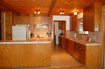 a kitchen with wooden cabinets and a white refrigerator at 43A Mountain Retreat in Wawona