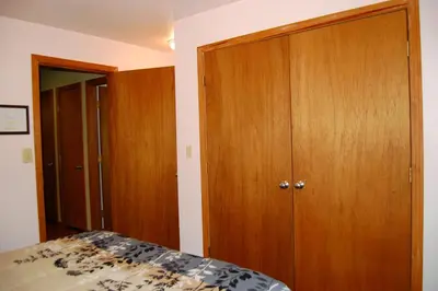 a bedroom with a bed and a wooden closet at 5N Edmond's Place in Wawona