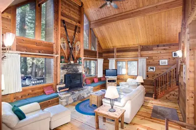 a living room with a fireplace in a log cabin at 41A Cedar Chalet in Wawona