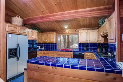 a kitchen with wooden cabinets and blue tile counter tops at 41A Cedar Chalet in Wawona