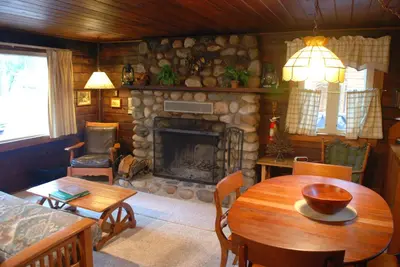 a living room with a table and a fireplace at 18 Le Fawn in North Wawona