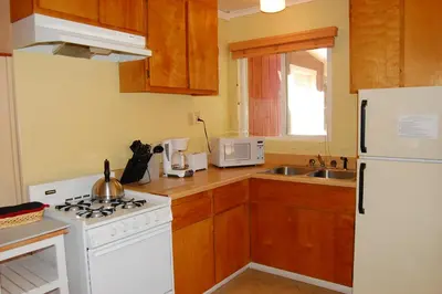 a kitchen with a white stove and a white refrigerator at 65 Sparrows Nest in Wawona
