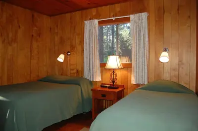 a bedroom with two beds and a window and a lamp at 92 Harmony Villa in Wawona
