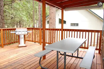 a picnic table on a deck with a grill at 92 Harmony Villa in Wawona