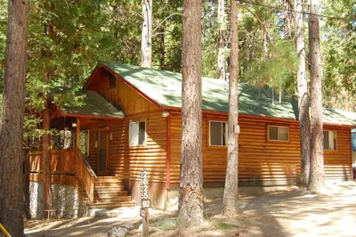a log cabin in the middle of a forest at 92 Harmony Villa in Wawona