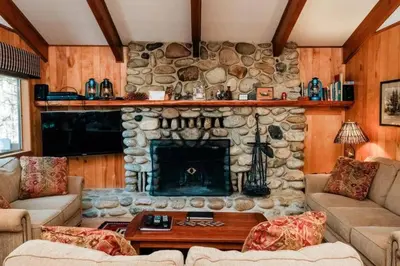 a living room with a stone fireplace in a house at 19B Yosemite Retreat in the Meadows in Wawona