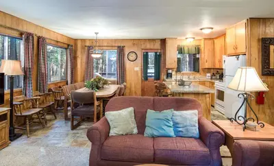 a living room with a couch and a kitchen at 4 Pine Creek Cabin in North Wawona