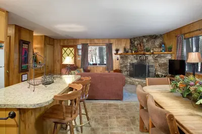 a kitchen and living room with a couch and a fireplace at 4 Pine Creek Cabin in North Wawona