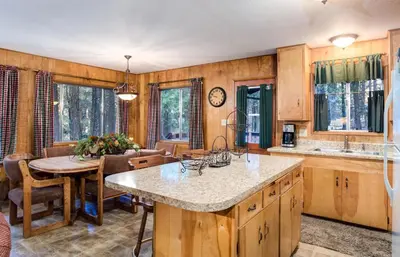 a kitchen with a table and a dining room at 4 Pine Creek Cabin in North Wawona