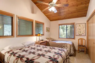 a bedroom with two beds and a ceiling fan at 12 Cabin Twelve in Wawona