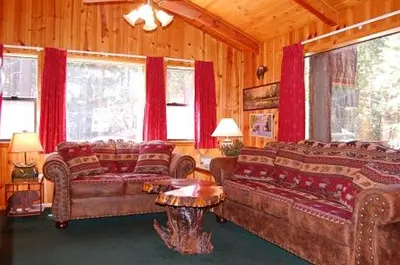 a living room with leather couches and red curtains at 93R Deer Lodge in North Wawona