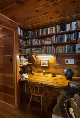 a library with a wooden desk and shelves of books at 37 Wapiti in North Wawona