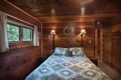 a bedroom with a bed in a wooden room at 37 Wapiti in North Wawona