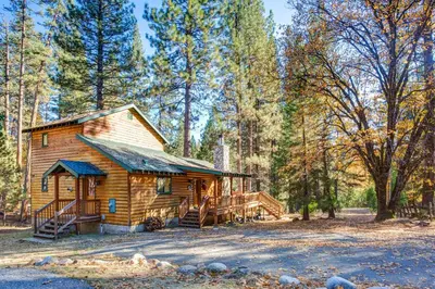 a log cabin in the woods with a staircase at 21 River Refuge in North Wawona