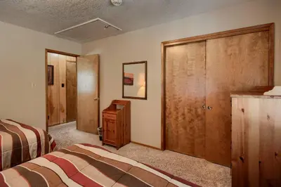 a bedroom with a bed and a wooden closet at 69 Bordentown West in Wawona