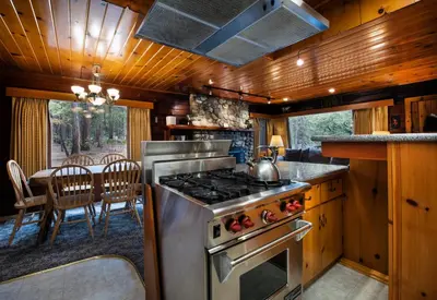 a kitchen with a stove and a dining table at 72 Sequoia in North Wawona