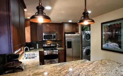a kitchen with wooden cabinets and stainless steel appliances at 9 Boot's Haven in North Wawona