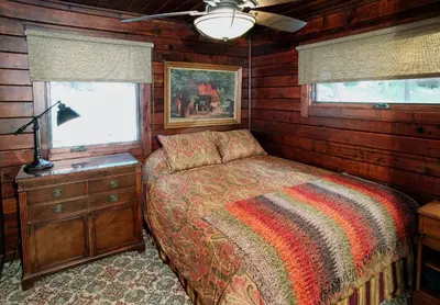 a bedroom with a bed and a dresser and a window at 9 Boot's Haven in North Wawona