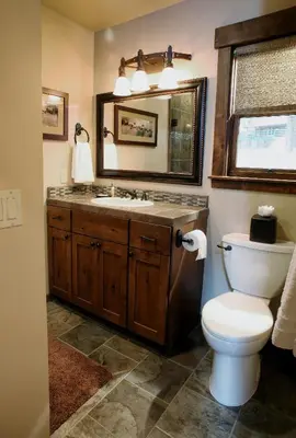 a bathroom with a toilet and a sink and a mirror at 9 Boot's Haven in North Wawona