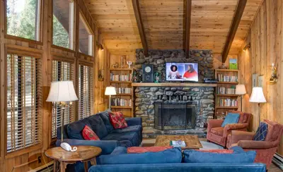 a living room with a stone fireplace and blue couches at 17B Tylers Timber Lodge in Wawona