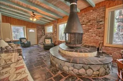 a living room with a brick wall and a fire place at 95R The Little Creek Cabin in Wawona