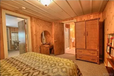 a bedroom with a bed and a dresser and a mirror at 95R The Little Creek Cabin in Wawona