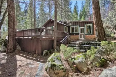 a log cabin in the woods with trees at 95R The Little Creek Cabin in Wawona