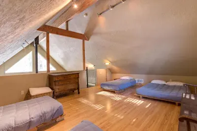 a attic room with two beds and a window at 7S Wawona Chalet in Wawona