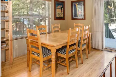 a wooden dining room table with chairs and a window at 7S Wawona Chalet in Wawona
