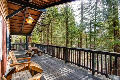 a porch of a cabin with benches and a table at 18B Hiltbrand Hangout in Wawona