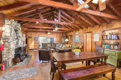 a living room with a table and a stone wall at 50R Soots-Me in Wawona
