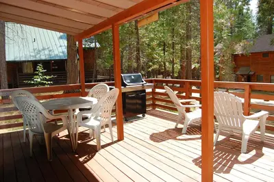a deck with a table and chairs and a television at 35 Cubbys Den in Wawona