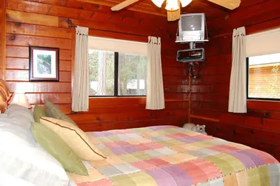a bedroom with a bed and a tv in it at 35 Cubbys Den in Wawona