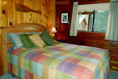 a bedroom with a colorful bed with a window at 35 Cubbys Den in Wawona