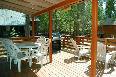 a wooden deck with a table and chairs on it at 35 Cubbys Den in Wawona