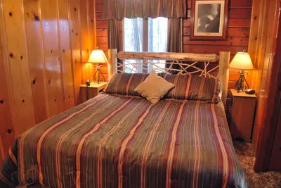a bedroom with a bed with a striped comforter at 79 Half Dome in Wawona