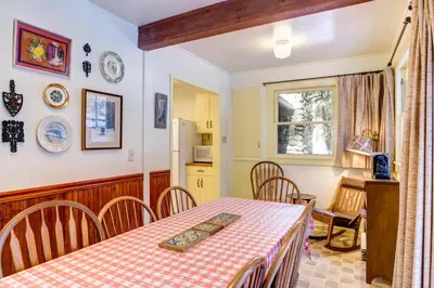 a kitchen and dining room with a table and chairs at 80 Chattertons Cottage in North Wawona