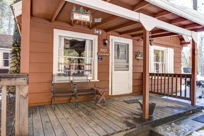 a tiny house with a porch and a deck at 80 Chattertons Cottage in North Wawona