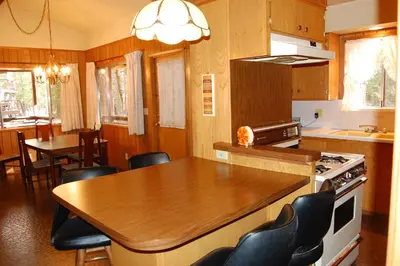 a kitchen with a wooden table and a table and chairs at 84 Hastings Hideaway in Wawona
