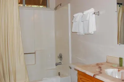 a white bathroom with a shower and a sink at 47R Altitude Adjustment in North Wawona